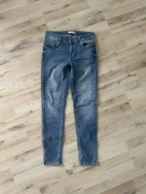Blå skinny jeans från Coster copenhagen  - Snygga blå skinny jeans från coster copenhagen med klassisk femficksdesign och dragkedjegylf. Jeansen har en lätt tvättad look och smala ben som sitter tight hela vägen ner. Perfekta för en trendig och avslappnad stil.