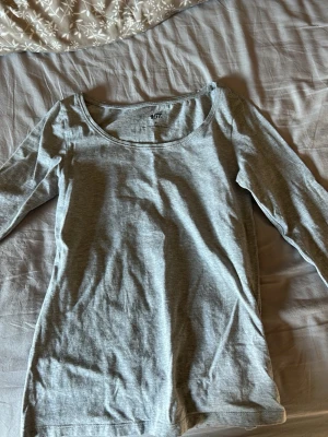 Ljusgrå långärmad topp - En basic ljusgrå långärmad topp med lite uringning. Använts fåtal gånger. Pris går att diskuteras!