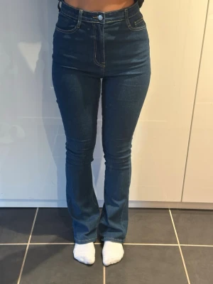 Blå high waist bootcut byxor - Blå high waist byxor med bootcut-modell. Snygg passform som framhäver midjan och sitter tight över låren. Storlek 36 men passar även 38 då de är stretchiga 