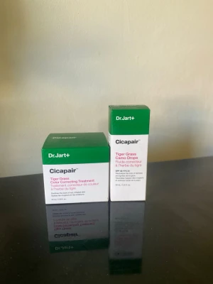 Dr.Jart+ Cicapair Tiger Grass Foundation - Dr.Jart+ Cicapair Tiger Grass Color Correcting Treatment och Camo Drops är foundations med färgkorrigerande egenskaper. Förpackningarna är vita och gröna, och produkten innehåller tigergräs som lugnar huden. Perfekt för att jämna ut hudtonen och ge en naturlig finish.