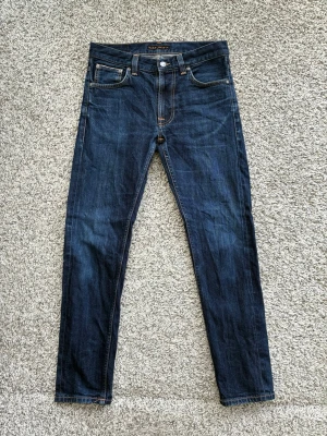  Nudie Jeans - Lean dean - Säljer ett par mörkblå skinny jeans från Nudie Jeans (modell Lean Dean) med klassisk femficksmodell. Jeansen har en smal passform. Jättefint skick! Storlek 30/30.