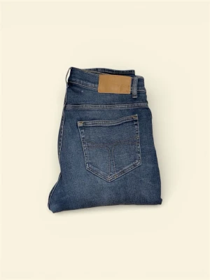 jeans  tiger of Sweden  - Snygga blå slim fit jeans från tiger of Sweden  med klassisk femficksdesign och diskreta slitningar framtill. Jeansen har normal midja, dragkedjegylf och en läderpatch bak i midjan. Tillverkade i mjuk denim med lite stretch för extra komfort. Har en liten fläck men inget man tänker på. 