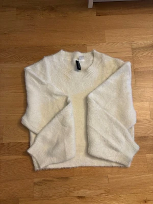  stickad tröja - Mysig vit stickad tr sin tröja från H&M med fluffig känsla. Tröjan har rund halsringning, långa ärmar och ribbade muddar vid ärmslut och nederkant autocool. Perfekt för lager på lager och enkel att matcha med jeans eller kjol.