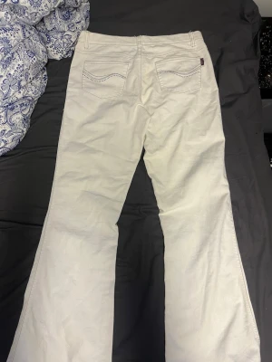 Vita bootcut jeans från Cemasi - (Kom med ett pris, så kan vi diskutera vidare).😀Säljer ett par vita bootcut jeans från Cemasi, jag skulle säga att det är storlek 38. Det är snygga detaljer i form av silverfärgade nitar på bakfickorna. Perfekta för dig som gillar retrovibbar och vill sticka ut lite extra.🥰