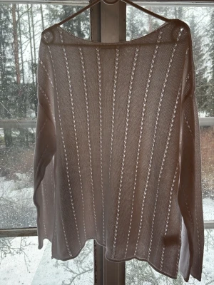 Vit stickad tröja med hålmönster - Säljer en vit stickad tröja med tunna vertikala hålmönster och lång ärm. Tröjan har en lös passform och är tillverkad i ett lätt material, perfekt för lager på lager. Enkel och stilren design som passar till mycket. Perfekt tröja till våren!