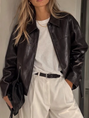 Brun oversized skinnjacka - Snygg brun oversized skinnjacka med klassisk krage och dragkedja framtill. Helt ny i sitt tagg. Jackan har raka ärmar med dragkedjedetaljer vid ärmsluten och en stilren, minimalistisk look. Perfekt för dig som vill ha en trendig och tidlös jacka i garderoben.