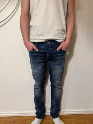 Blå slim fit jeans från jack&jones  - Säljer ett par blå slim fit jeans med snygga tvättade detaljer. Jeansen har klassisk femficksmodell, knappgylf och smal passform. Perfekta för en avslappnad och trendig look. W30 L30