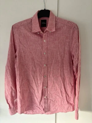 Rosa Oscar Jacobson linneskjorta S - Väldigt snygg populär rosa linneskjorta från Oscar Jacobson av högsta kvalite i storlek S säljes! Väldigt fint skick inga hål eller fläckar så riktigt kap! Perfekt nu till sommaren och tveka inte vid minsta fråga.
