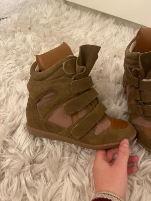 Marant skor  - Säljer ett par marant skor. Skorna har en mix av mocka och skinnliknande material samt detaljer i olika bruna nyanser och kakai. Fick dessa i present utan kvitto så vet ej till 100% om dom är äkta. Använda 2 gånger då de är för stora för mig. Skorna har kallare nyanser IRL. 