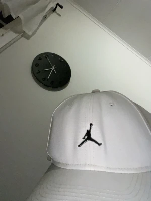 Vit Jordan keps med silvrig logga - vit keps från Jordan med den klassiska silvriga jumpman framtill. Kepsen har böjd skärm och justerbar passform baktill. Riktigt trevlig i använd men okej skick! Hör av innan köp gärna 🤝