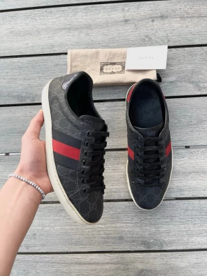 Gucci Ace svarta sneakers  - Gucci Ace i en riktigt populär och snygg modell, perfekta sommarskor! Toppskick, inga tydliga defekter. Dustbag och kort ingår. Storlek us 7,5, passar 41/42.  Kontakta mig för fler frågor och funderingar!