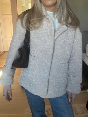 Beige Teddy kappa  - Säljer en super snygg kappa i teddy-material, perfekt till våren!! Jackan har en avslappnad passform och stängs framtill. Skriv för fler bilder om ni vill se stängd med knappar!! Den är overzised i passformen så funkar för både s och m💕