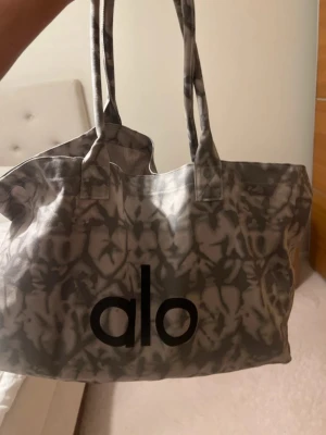 Alo shopping tote bag - Snygg shoppingväska från Alo i grått batikmönster med stora svarta loggan framtill. Perfekt för träning eller annat 