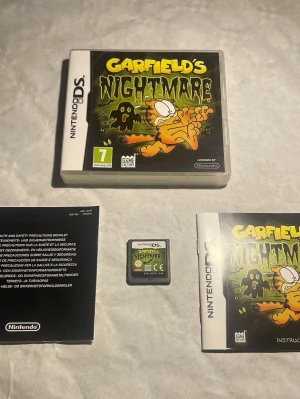 Garfield's Nightmare Nintendo DS spel - Garfield's Nightmare till Nintendo DS är ett plattformsspel med färgstark omslagsdesign i svart, grön och gul. Spelet kommer i plastfodral med originalmanualer och spelkassett. Perfekt för dig som gillar klassiska tecknade figurer och äventyr.