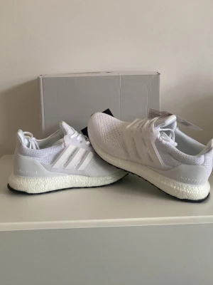 vita sneakers - Fräscha sneakers i helvitt med stickad ovandel och klassiska tre ränder på sidan. Skorna har en tjock, vit sula för maxad komfort och svart yttersula. Perfekta för dig som gillar stilrena och sportiga sneakers.