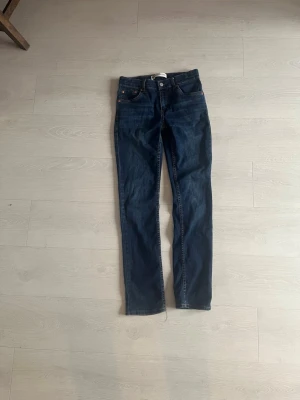 Mörkblå jeans från Levi's - Snygga mörkblå slim taper jeans från Levi's med klassisk femficksdesign och gylf med knapp. Jeansen har en smal passform och är tillverkade i denim med lätt stretch för extra komfort. Perfekta för en trendig och avslappnad look.
