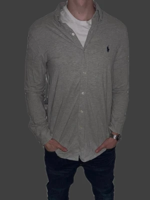 Grå skjorta från Ralph Lauren - Grå skjorta från Ralph Lauren i storlek M.  Fint skick till ett bra pris. Nypris: 1995kr. Mitt pris: 349kr. Vid frågor eller funderingar, tveka inte att höra av dig.