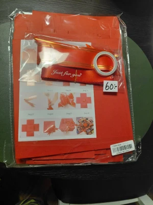 Presentinslagningskit röd - Nytt Ett komplett presentinslagningskit i rött med presentpåsar, satinband med texten 'Just for you', dekorband och instruktioner för att vika rosetter. Perfekt för att slå in gåvor på ett snyggt och personligt sätt. Allt är förpackat i plast.