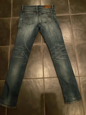 TOS jeans  - Snygga blå slim fit jeans med slitningar och tvättade detaljer. Notera alla hål på framsidan annars i mycket fint skick. 