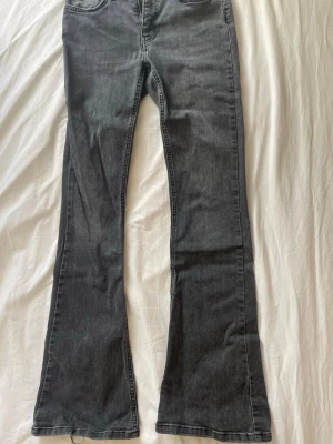 Grå bootcut jeans från Perfect Jeans - Snygga grå bootcut jeans från Perfect Jeans med klassisk femficksmodell. Jeansen har en lätt utsvängd passform nedtill och är tillverkade i ett mjukt denimtyg som ger en avslappnad look. Low to mid waist