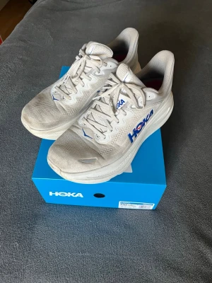 Hoka bondi 9 - Skor från Hoka | Storlek: 46 2/3 | Färg: vit med blå text | Använda i 3 månader | Skick efter bilderna | Nypris 2399 | Mjuk med maximal dämpning |