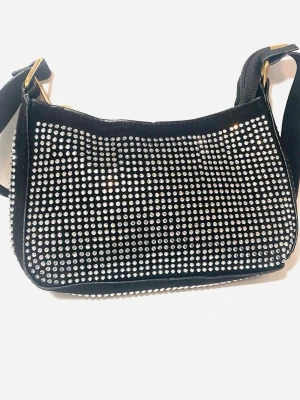 Handväska med strass stenar  - Handväska i svart mocka imitation med silver strass stenar på båda sidorna , dragkedja och halvlånga axelband . Aldrig används 