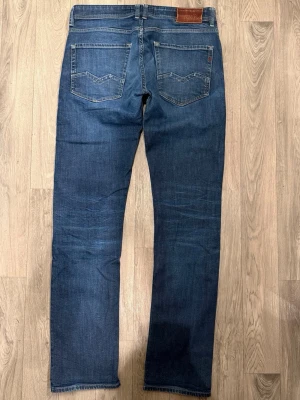Replay Rocco Mörkblå Jeans W32/L34 Regular Fit - Replay Rocco mörkblå jeans i clean tvätt, regular rak passform som sitter bra och funkar till allt, storlek W32/L34, midja 42,5 cm, ytterbenslängd 109 cm, benöppning 18,5 cm, modellen är 185cm & väger 65kg, i fint skick.