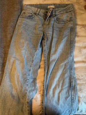 Ljusblå raka jeans från Gina Tricot - Säljer ett par ljusblå jeans från Gina Tricot med rak passform och klassisk femficksdesign. Jeansen har normalhög midja, bälteshällor och snygga sömmar. Materialet är denim i bomull och de har en avslappnad vibe.