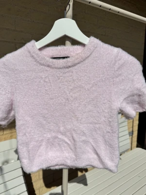 Ljusrosa fluffig topp Forever 21 - Supersöt ljusrosa fluffig topp från Forever 21 inköpt i Miami. Mjuk & skön. XS. Superfint skick MEN… OBS! OBS! tyvärr har ärmarna blivit avklippta (korkat gjort 🫣) så du måste fålla dem så de inte repar upp sig. Därav billig!  💖