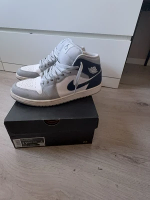 Air Jordan 1 Mid Wolf Grey Midnight Navy  - Säljer ett par sjukt fräscha Air Jordan 1 Mid i färgen Wolf Grey / Midnight Navy. Använda väldigt lite (2–5 gånger), i princip som nya 👌 Storlek: 45.5✔️(passar även 44).         Skick: 9/10✔️ Originalbox ingår✔️ Inga märken eller skador  Perfekta vardagssneakers med clean färg som passar till allt.  💰 Pris: 999 kr (kan diskuteras vid snabb affär)