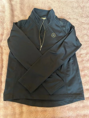 Mörkblå ridtröja - Mörkblå långärmad tröja från Hööks, tröjan är helt oanvänd och ingen slitning. Säljer då jag den aldrig kom till användning och nu är för liten 
