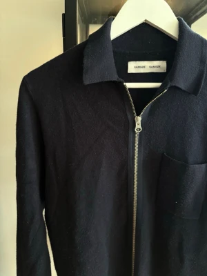 Svart ziptröja från Samsøe Samsøe - Stilren mörkblå ziptröja från Samsøe Samsøe med krage och bröstficka. Tröjan är något nopprig men det är inget som inte går att fixa! Finns även i mörkgrön på min profil