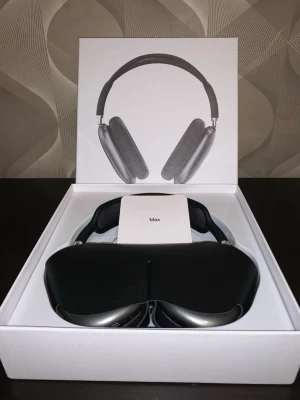 Apple AirPods Max hörlurar grå - Snygga over-ear hörlurar från Apple, modell AirPods Max i rymdgrå färg. De har en stilren design med aluminiumkåpor, meshbygel och mjuka öronkuddar. Levereras i originalförpackning med smart skyddsfodral.