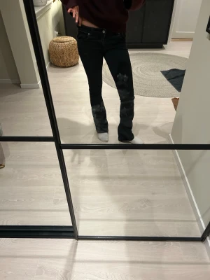 Svarta bootcut jeans - Säljer ett par svarta bootcut jeans med klassisk femficksmodell och normal midja. Jeansen har en snygg passform som sitter tight upptill och släpper ut vid bensluten. Perfekta till sneakers eller boots och passar till det mesta i garderoben.