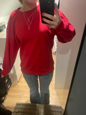 Röd basic zara tjocktröja  - En enkel röd sweatshirt med rund hals och långa ärmar. Tröjan har en avslappnad passform och ribbade muddar vid ärmslut och nederkant. Perfekt att matcha med jeans för en casual look.