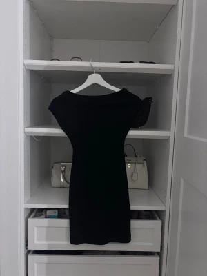 Svart tight kortklänning - En svart, tight kortklänning med djup urringning i ryggen. Från Zara 