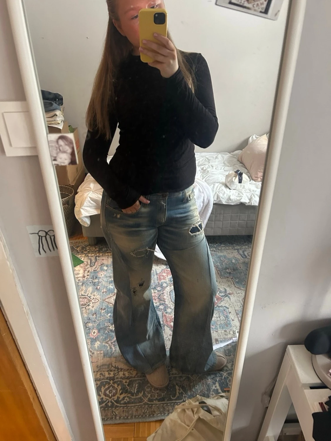 Blåa utsvängda slitna jeans