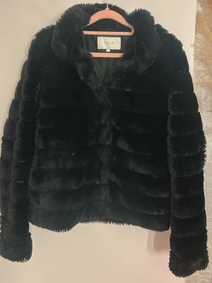 Svart pälsjacka från VILA - Säljer en svart pälsjacka från VILA i storlek 34. Jackan har en fluffig och mjuk fuskpäls💕