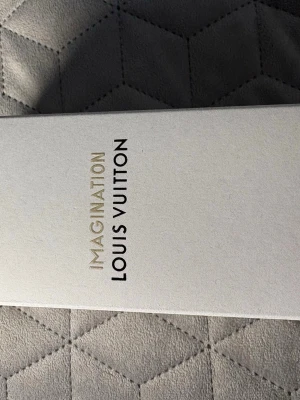 Louis Vuitton Imagination parfym - Lyxig parfym från Louis Vuitton med namnet Imagination. Förpackningen är elegant och stilren i ljusbeige kartong med guldfärgad och svart text. Perfekt för dig som vill ha en exklusiv doft i samlingen.