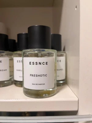 ESSNCE Freshotic & Hotter Mimosa parfym - Två Eau de Parfum från ESSNCE: Freshotic och Hotter Mimosa. Flaskorna är cylinderformade i genomskinligt glas med minimalistiska vita etiketter och svarta lock. Modern och stilren design som passar perfekt på parfymhyllan.