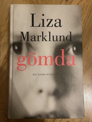 Gömda av Liza Marklund - En spännande roman med hård pärm, skriven av Liza Marklund. Perfekt för dig som gillar gripande och verklighetsbaserade berättelser.