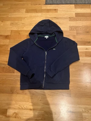 Lacoste hoodie - Mörkblå Lacoste hoodie i väldigt bra skick. Fick denna i julklapp men den passade inte och därför säljs den. Har användt den endast 4 gånger och den har inga defekter eller liknande. Storlek: 16y men sitter som XS Nypris: 1200 Kr (≈100€) Vårt pris: 449 Kr (≈40€) Hör av dig om minsta frågan. Priset är prutbart vid enkel affär