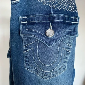 True Religion jeans med diamanter - Snygga True Religion jeans med coolt diamanttryck i bak! Mycket bra skick, använda ett fåtal gånger. 