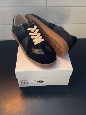 Svarta Maison Margielas.  - Svarta Maison Margielas storlek 43. Mycket bra skick. Låda  och dust bag medföljer. Pris går att sänkas vid snabb affär. 