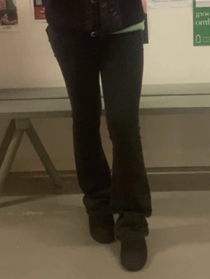 Svarta bootcut jeans - Säljer ett par svarta bootcut jeans med klassisk femficksdesign. De sitter jättebra, personligen gillar jag de väldigt mycket! Jeansen har en något utsvängd passform nertill och är perfekta för en avslappnad men ändå trendig look. Passar dig som gillar stilrena och mångsidiga jeans. Storlek S, full length, hög midjade.