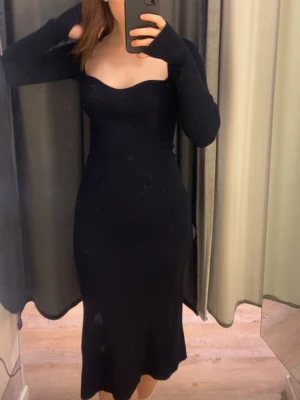Stickad klänning bikbok - Säljer en svart, långärmad klänning från Bik Bok med ribbad struktur och figurnära passform. 