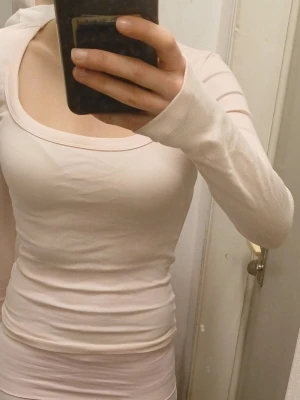 Ljusrosa långärmad tröja  - Säljer en ljusrosa långärmad topp med ribbad struktur och rundad halsringning. Toppen är figurnära och har en enkel, stilren design som passar perfekt till jeans eller kjol.💕