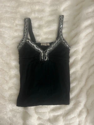 Festtopp  - Så fin Festtopp med silverdetaljer! Några lösa trådar, se sista bilderna. Står strl M men skulle snarare säga XS/S