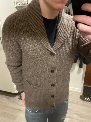Brun stickad cardigan - Otroligt snygg brun stickad cardigan från Selected homme. Passar perfekt till kallare väder. Modellen är 180cm, 75kg. Priset kan såklart diskuteras!