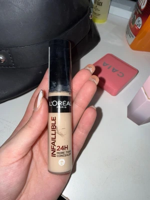 L'Oréal Infaillible Concealer 322 - Ljusbeige concealer från L'Oréal Paris, Infaillible 24H More Than Concealer i nyansen 322 Neutral. Kommer i en smidig tub med svart lock och applikator. Perfekt för att täcka mörka ringar och ojämnheter med ett naturligt resultat. Använd 2 gånger 
